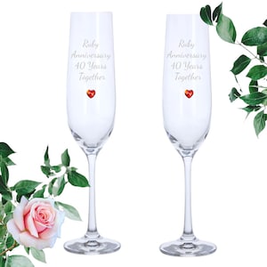 May include: Two clear glass champagne flutes with the text "Ruby Anniversary 40 Years Together" and a small red heart on each.