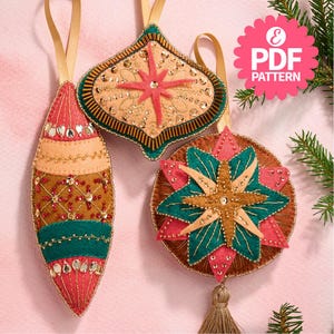 May include: Three felt Christmas baubles with a star design and beaded accents. The baubles are in shades of red, green, brown, and gold. The baubles are hanging against a white background.