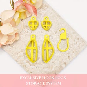 May include: A set of five bright yellow plastic components for an exclusive hook lock storage system. The set includes two small triangular pieces, two larger elongated teardrop-shaped pieces, and one hook-shaped fastener, all featuring a cross-bar design.