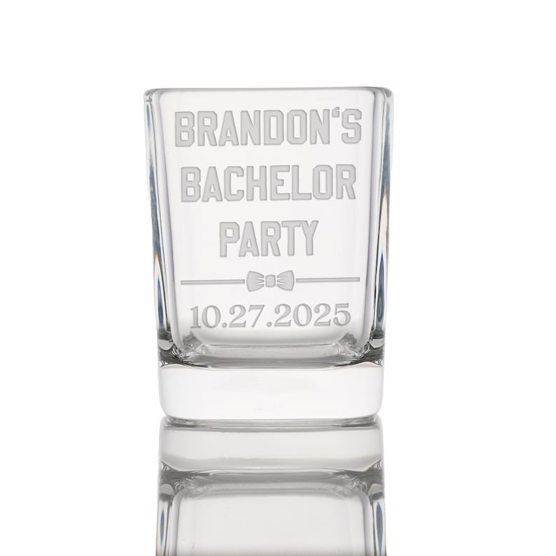 Puede incluir: Un vaso de vidrio transparente con el texto "BRANDON'S BACHELOR PARTY 10.27.2025" grabado en el lateral. Tambi&eacute;n se graba un s&iacute;mbolo de pajarita en el vaso.