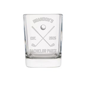 May include: Clear glass shot glass with etched golf-themed design. The design includes crossed golf clubs, a golf ball, and the text "Brandon's", "EST. 2025", and "BACHELOR PARTY".