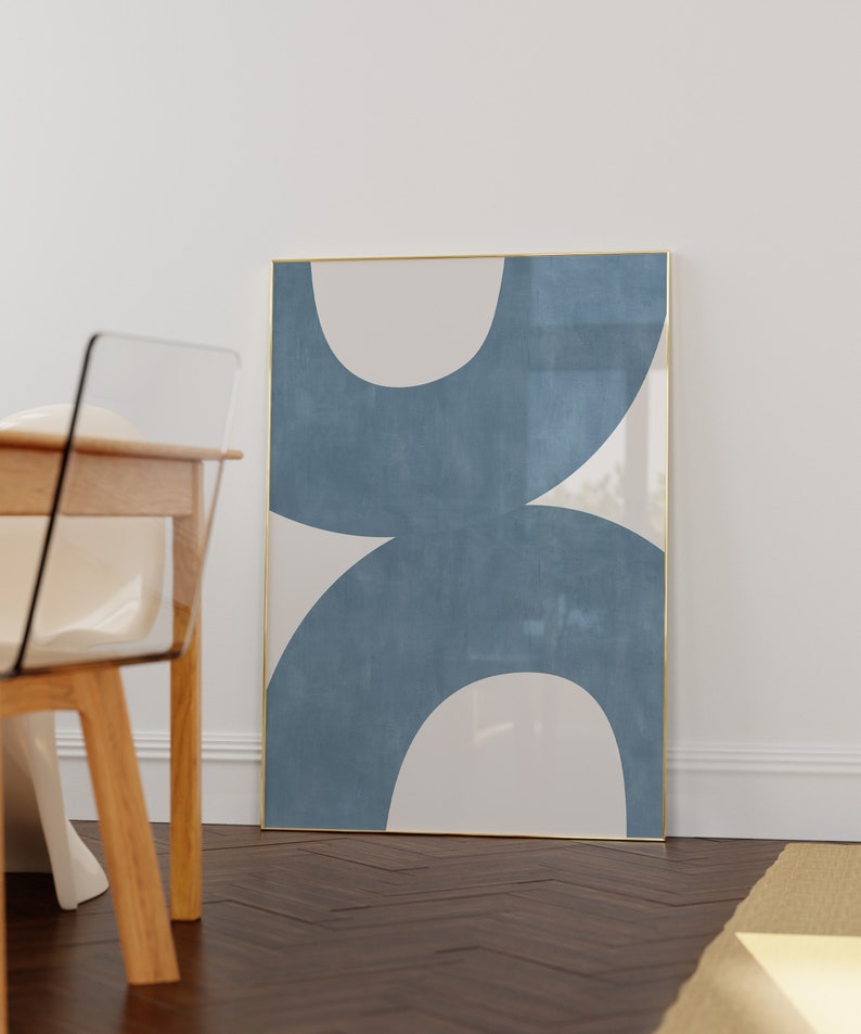 May include: A framed abstract art print with a blue and white design. The print features two large, overlapping circles in a light blue color with a white background.