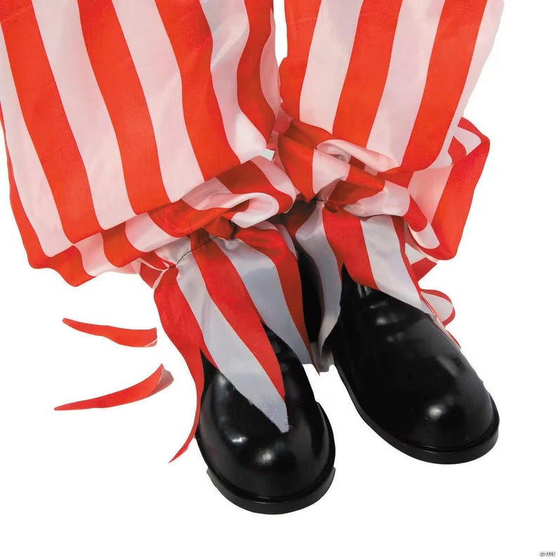 May include: A pair of black, shiny clown shoes with red and white striped pants. The pants are gathered at the ankles and have a ruffled appearance. The image is set against a white background.