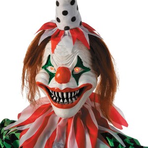 May include: A scary clown mask with red hair, a white face, and a large red nose. The clown has green diamond-shaped eye makeup and a wide, menacing grin revealing sharp teeth. The clown's collar is red and white striped.