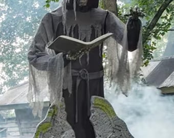 May include: A Halloween grim reaper figure standing behind a tombstone. The reaper is dressed in a gray hooded robe and holds a book. The tombstone is gray with green moss and skull details. Red glowing eyes are visible.