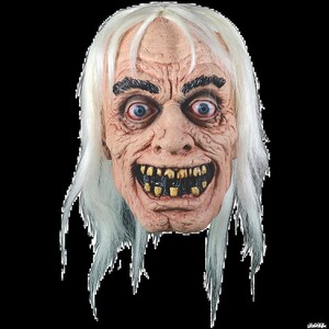 May include: A white-haired, grotesque mask with a wide, toothy grin. The mask is made of latex and has a realistic appearance. The eyes are blue and the teeth are yellow.