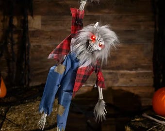 May include: A hanging werewolf decoration with glowing red eyes, grey fur, and a skeletal hand reaching upward. The figure wears a red and black buffalo plaid flannel shirt over blue denim overalls with patches, featuring exposed skeletal arms and legs.