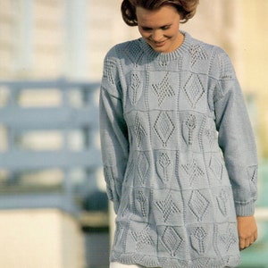 Könnte beinhalten: Ein hellblauer Strickpullover mit geometrischem Muster. Der Pullover hat einen runden Ausschnitt und lange Ärmel.