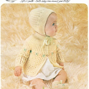May include: A yellow knitted baby cardigan and bonnet set with a floral design. The set is made with 4 ply yarn and is suitable for a chest size of 18-20 inches.