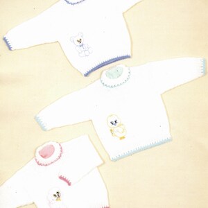 May include: Three white knitted baby sweaters with animal designs. One sweater has a teddy bear, another an owl, and the third a puppy. Each sweater has a contrasting color trim around the neck, cuffs, and hem. The sweaters are sized for 16-22 inches (41-56 cm).