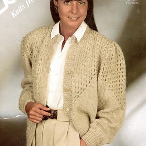 Könnte beinhalten: Ein beigefarbener Strickcardigan mit Knopfleiste und einem zarten Lochmuster. Der Cardigan wird an einem Model gezeigt, das ein weißes Hemd mit Kragen und eine beige Hose trägt. Der Text "Robin Knits from 4 balls" und "15051c Feelings FASHION DK 71-107 cm 28-42 in. Four sizes" ist auf dem Bild sichtbar.