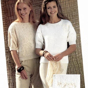 May include: Two women wearing knitted tops and pants pose for a photo. One woman wears a cream-colored top with short sleeves and matching pants. The other woman wears a white top with short sleeves and matching pants. The image includes the text "A368 EASY KNIT."