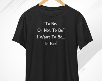 May include: Black t-shirt with white text that reads "To Be, Or Not To Be" I Want To Be... In Bed