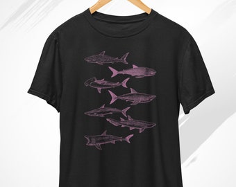 May include: Black t-shirt with a pink graphic of a school of sharks swimming in a line.
