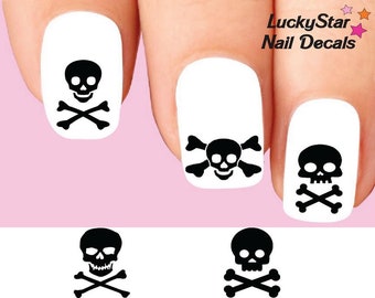 May include: White nail decals featuring black skull and crossbones designs. The decals include the text "LuckyStar Nail Decals" in black. The nail art is displayed on a pink background.