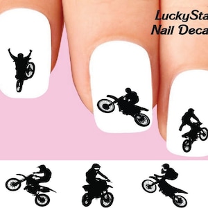 May include: Nail decals featuring black silhouettes of motocross riders performing stunts on white nail backgrounds. The decals include the text "LuckyStar Nail Decals".