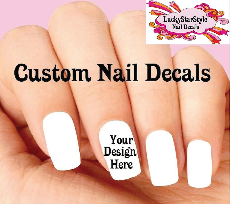 May include: A hand with five fingernails, each painted white. One nail features the text "Your Design Here." The words "Custom Nail Decals" are above the nails. A logo for "LuckyStarStyle Nail Decals" is in the upper right corner.