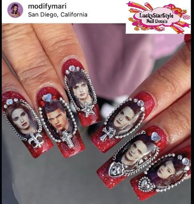 May include: Red glitter nail art featuring portraits of characters from a movie, framed with silver chains and embellishments. Each nail showcases a different character, with various charms and gems. The nails are long and almond-shaped.