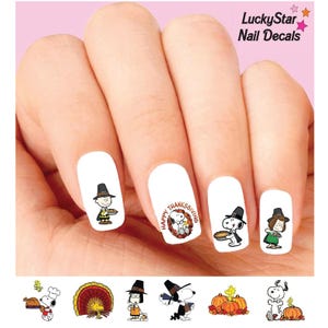 May include: LuckyStar Nail Decals featuring Peanuts characters in Thanksgiving attire. The decals include Snoopy, Charlie Brown, and Woodstock with pumpkins, turkeys, and pies. The text reads LuckyStar Nail Decals and Happy Thanksgiving.