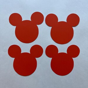 May include: Four red paper cutouts shaped like Mickey Mouse heads.