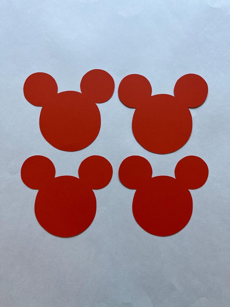 May include: Four red paper cutouts shaped like Mickey Mouse heads.