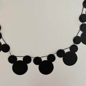 Puede incluir: Guirnalda de papel con tem&aacute;tica de Mickey Mouse en blanco y negro con cuerda negra. La guirnalda est&aacute; hecha de recortes de papel de cabezas de Mickey Mouse.