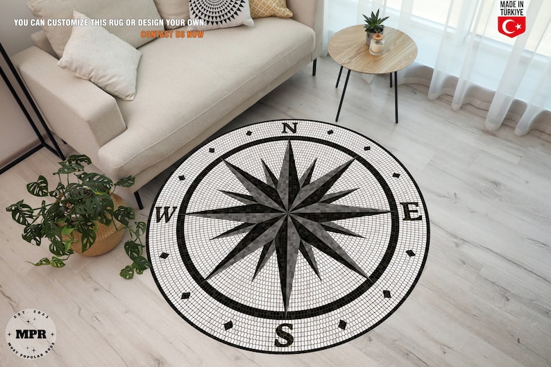 Pode incluir: Um tapete de b&uacute;ssola preto e branco com um design de mosaico. A b&uacute;ssola apresenta um design de estrela com as letras N, S, E e W.