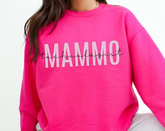 May include: A pink sweatshirt with the text "Mammo Technologist" in white lettering.