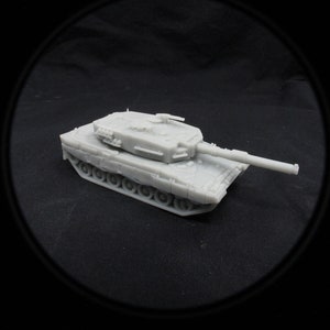 Puede incluir: Un modelo de tanque gris claro con un cañón largo y orugas detalladas. El vehículo militar en miniatura se encuentra sobre un fondo oscuro, mostrando su diseño y estructura. El tanque mide aproximadamente 15 cm de largo.