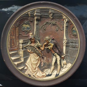 Schierholz & Sohn 455, ceramiczna, ręcznie malowana tablica ścienna z wizerunkiem pary zalotnej z okresu regencji, około 1880 r., średnica 37 cm.