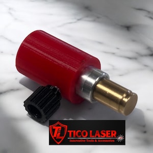 Pode incluir: Um bico de laser vermelho e prateado com um botão de ajuste preto. Tico Laser Ferramentas e acessórios inovadores.