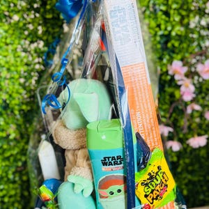 Pu&ograve; includere: Un set regalo in un cestino blu intrecciato con un fiocco blu, contenente un bagnoschiuma a tema Star Wars Mandalorian, un peluche e caramelle. Il set regalo &egrave; avvolto in cellophane trasparente.