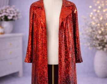 May include: A long, open-front sequin coat in a gradient of red to black. The coat is displayed on a mannequin, showcasing its long sleeves and collar. The sequins create a shimmering effect, adding a touch of glamour.