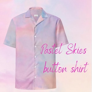 May include: A short-sleeved button-up shirt with a pastel color scheme of pink, blue, and lavender. The shirt has a classic collar and a button-down front. The words "Pastel Skies button shirt" are written in pink script.