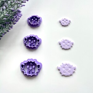 May include: Set of five purple plastic cookie cutters shaped like pufferfish. The cutters are arranged in a vertical line from largest to smallest.