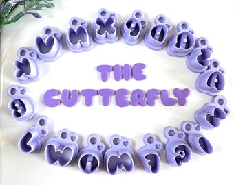 May include: Purple plastic cookie cutters shaped like letters spelling out "THE BUTTERFLY".