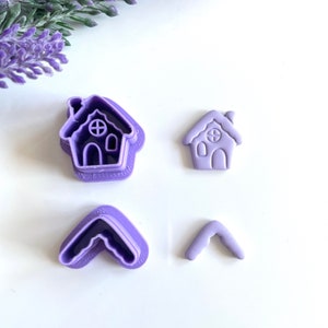 Peut inclure: Ensemble de quatre emporte-pièces en plastique violet. Deux emporte-pièces sont en forme de maisons avec une fenêtre et une cheminée. Deux emporte-pièces sont en forme de flèche.