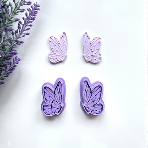 May include: Four purple butterfly-shaped silicone molds. The molds are designed to create detailed butterfly shapes.
