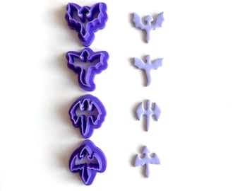 May include: A collection of purple plastic cookie cutters in the shape of bats. The cutters are in various sizes and designs, perfect for Halloween or themed baking. The image is set against a white background.