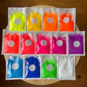 May include: Thirteen small bags of neon pigment powder, labeled with numbers 1 through 13. The powder is in various colors, including yellow, orange, red, pink, purple, blue, and green.