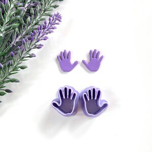 Könnte beinhalten: Zwei violette, handförmige Ausstecher aus Kunststoff und zwei violette, handförmige Ausstecher aus Kunststoff für Fondant.