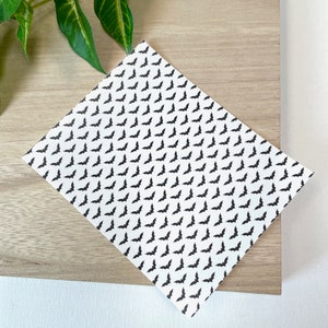 May include: White sheet of paper with a repeating pattern of black bats.