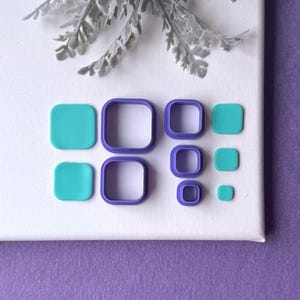 May include: A set of purple square-shaped cutters and matching teal square-shaped clay pieces in various sizes. The cutters have a hollow center and rounded corners, while the teal pieces are solid squares with matching rounded corners.