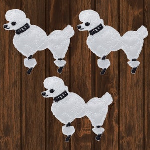 May include: Three white felt poodle dog iron-on patches with black collars and black embroidered details.