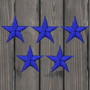 Puede incluir: Cinco parches en forma de estrella de fieltro azul. Las estrellas están cosidas con hilo blanco y tienen una textura ligeramente en relieve.