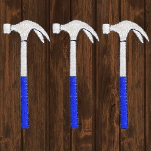 Op de afbeelding: Drie witte hamers met blauwe handvatten tegen een houten achtergrond.