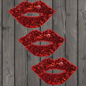 May include: Three red sequin lips patches. The lips are outlined in black and have a shiny, sparkly finish.