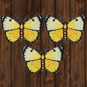 May include: Three yellow embroidered butterfly iron-on patches with black outlines.