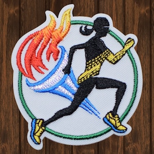 May include: An embroidered patch featuring a running figure with a yellow and black patterned outfit, holding a torch with a red, orange, and blue flame. The figure is running inside a green circle on a white background.