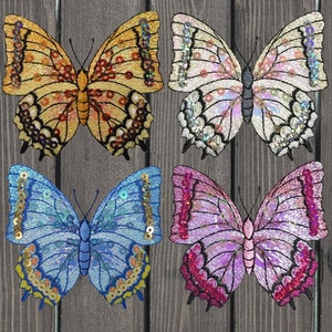 May include: Four embroidered butterfly patches with sequin details. The butterflies are in yellow, white, blue, and purple.